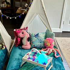 close up view of one of three teepees with a sea horse, octopus, pillows, and table tray