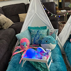 Close up photograph of one of three teepees with a blue pufferfish and multi-colored octopus that is predominately pink