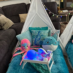 Close up photograph of one of three teepees with a blue pufferfish and multi-colored octopus that is predominately pink