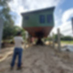 The contractor watching in anticipation as a house is raised onto the foundation he built.