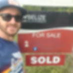 Me, the author, posing beside the for sale sign at our property