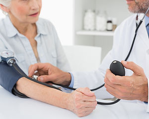 Doctor taking blood pressure of older pa