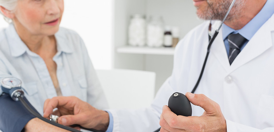 Doctor taking blood pressure of older pa