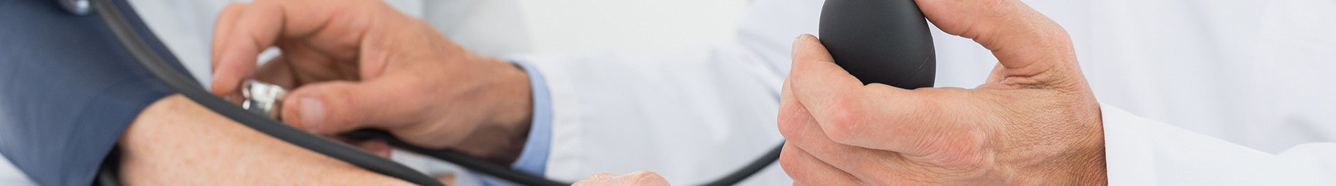 Doctor taking blood pressure of older pa