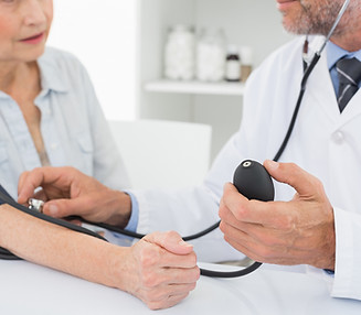 Doctor taking blood pressure of older patient