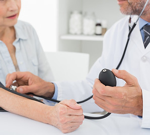 Doctor taking blood pressure of older pa