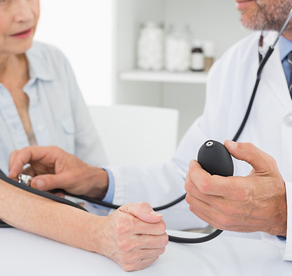 Doctor taking blood pressure of older patient