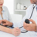 Doctor taking blood pressure of older patient
