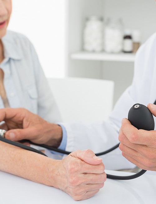 Doctor taking blood pressure of older patient