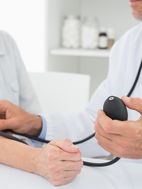 Doctor que toma la presión arterial del paciente anciano