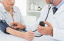 Doctor taking blood pressure of older pa