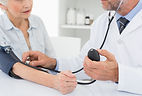 Doctor taking blood pressure of older pa