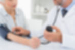 Doctor que toma la presión arterial del