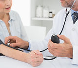 Doutor que toma a pressão sanguínea do p