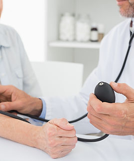 Doctor taking blood pressure of older patient