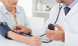 Doctor taking blood pressure of older pa