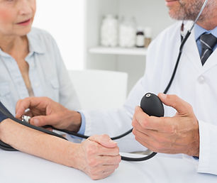 Doctor taking blood pressure of older patient