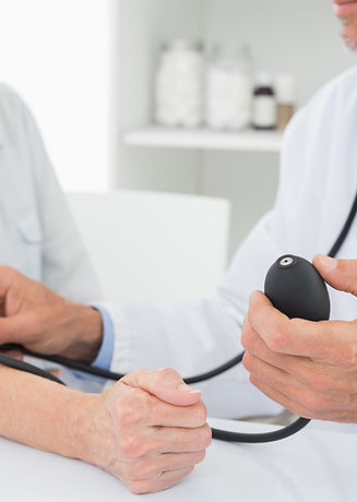 Doctor taking blood pressure of older patient