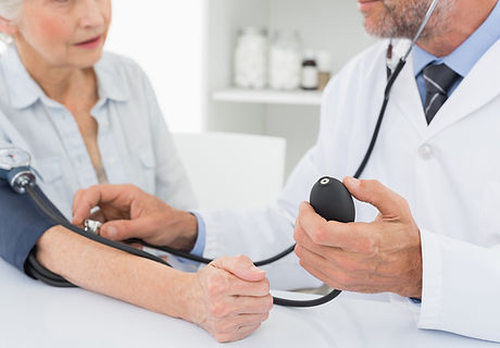 Doctor taking blood pressure of older patient
