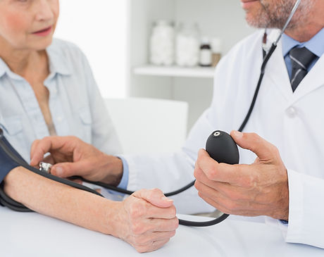 Doctor taking blood pressure of older patient