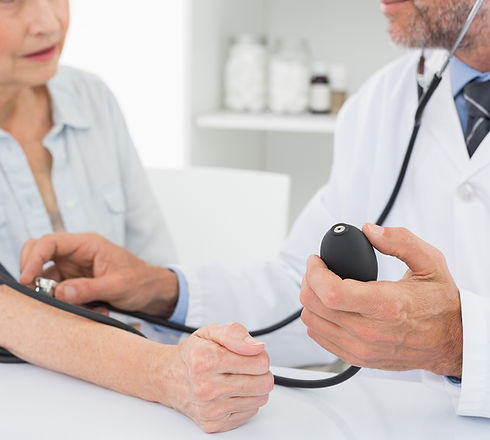 Doctor taking blood pressure of older patient