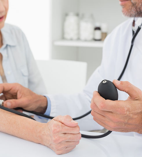 Doctor taking blood pressure of older patient