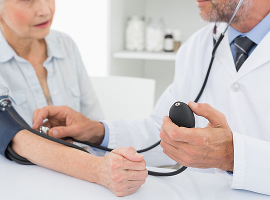 Doctor taking blood pressure of older patient