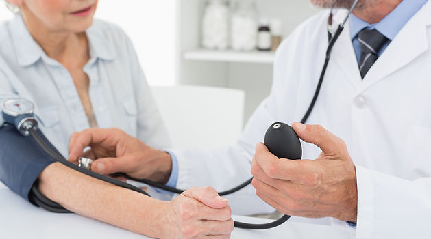 Doctor taking blood pressure of older pa