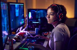 Teenage-Girl-Gamer-Wearing-Headset-Gaming