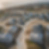 houses being built during development by a coastal city with roads and a gated community.j