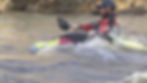 Kayaker in helmet paddling through rapids