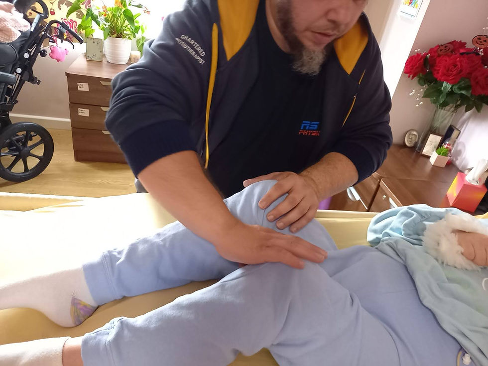Physiotherapist Pawel Ciecierski administering specialized treatment for posture correction and windswept posture to a patient seated on the hospital bed.