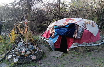 abgedeckte Schwitzhütte mit Altar nebendran