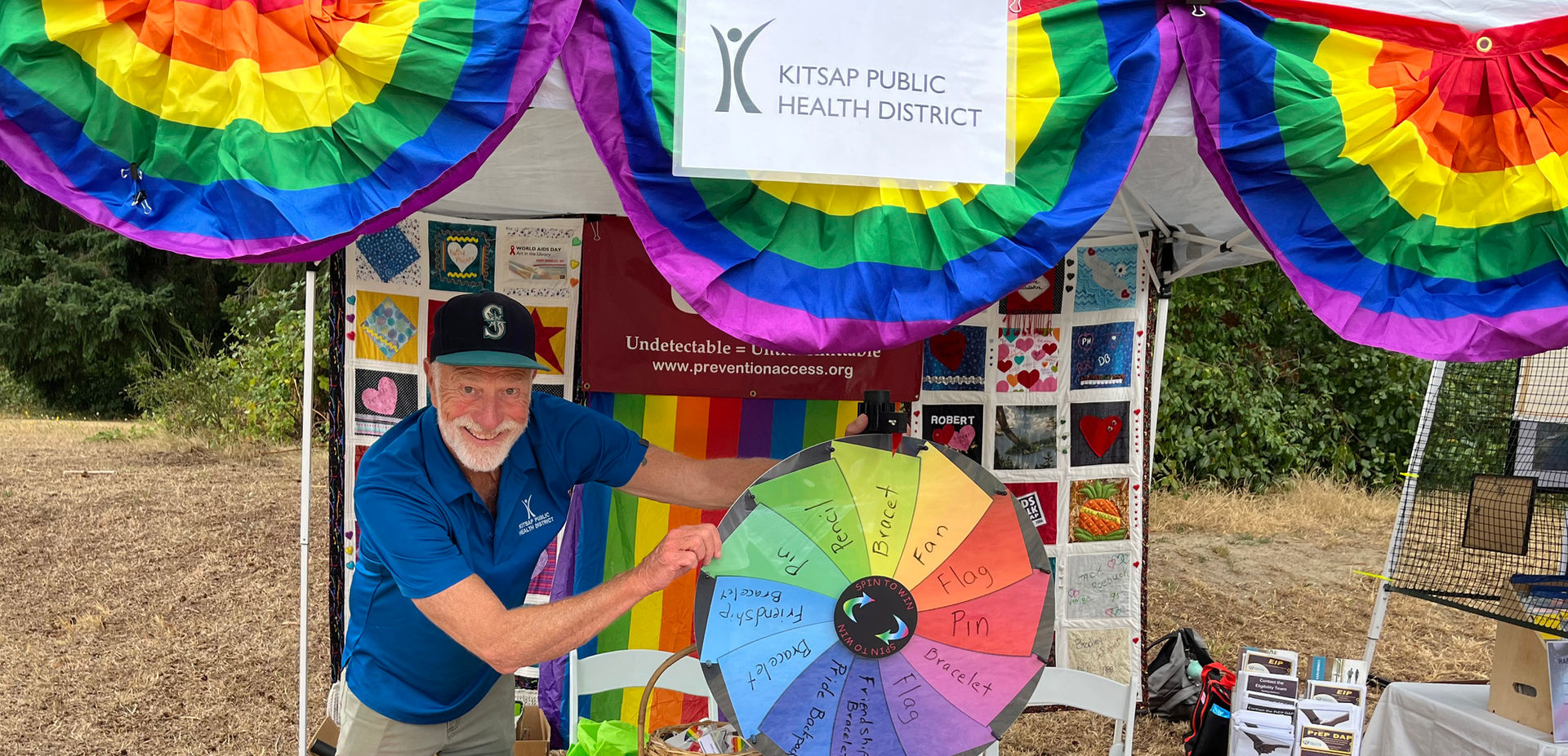 a KPHD employee at a rainbow-festooned booth
