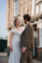Bride and groom facing each other outside of Dragon Hall in Norwich