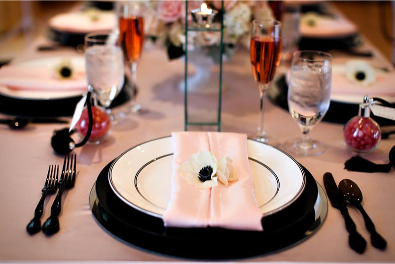 A charming table setting adorned with pink napkins and silverware, part of a French bridal shower celebration.