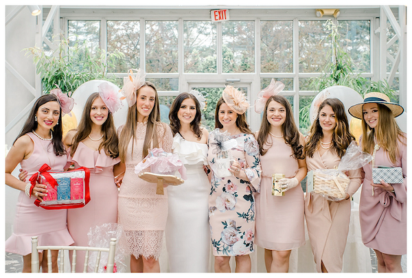 Women in pink dresses holding presents at a French bridal shower, adding a playful and festive touch to the celebration.