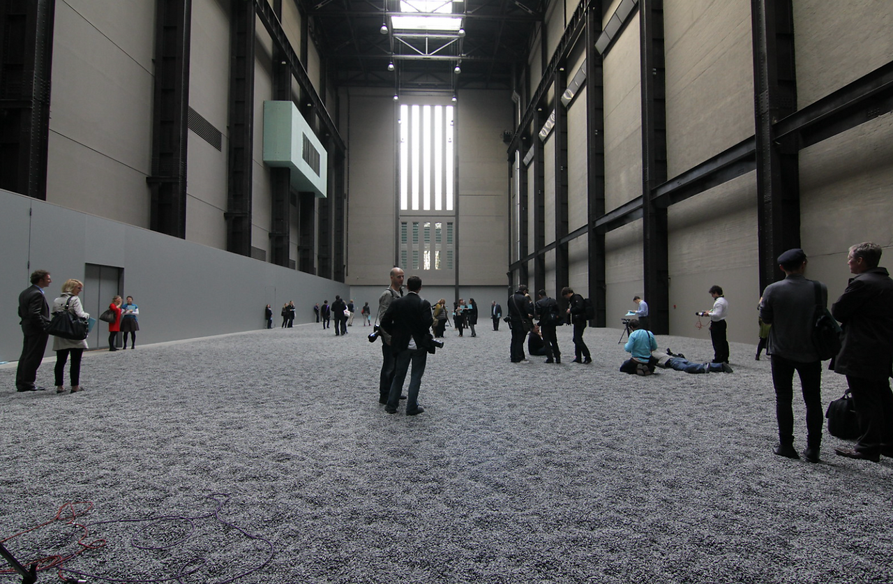 © Credit to photography Didier Leroi, visitors in the tate modern walking on a vast grey space of sunflower seeds