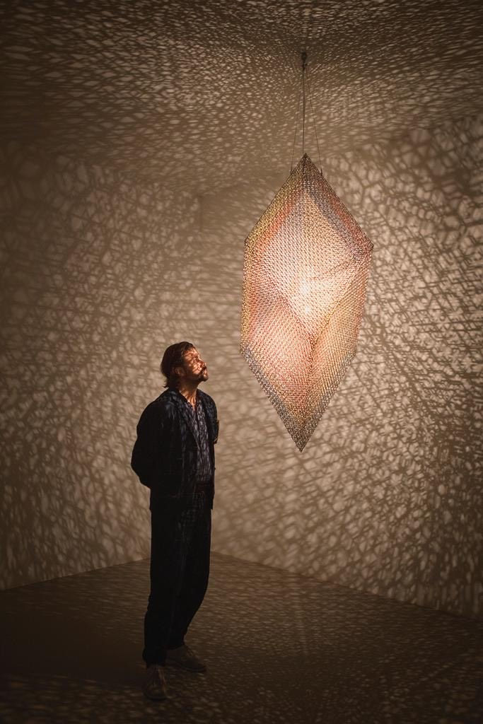 Conrad Shawcross standing in front of his artwork 'Slow Arc Inside a Cube XI' (2020) during the Noor Riyadh 2023 exhibition