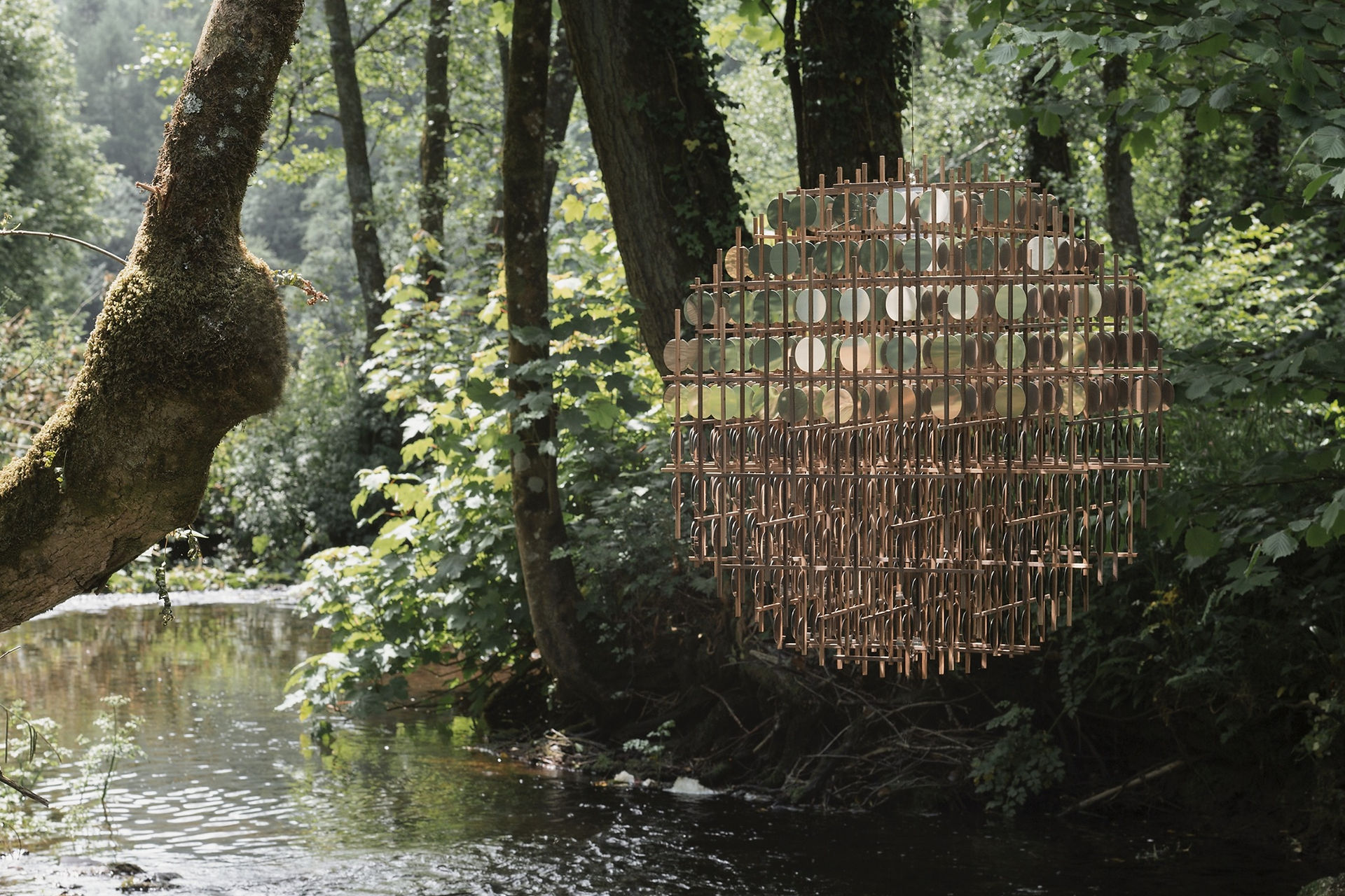 art installation above a british river made of golden coins in a sphere shape