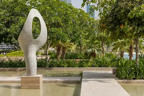 outdoor sculpture at one at palm dubai feature a henry moore inspired abstract cream sculpture in the water garden