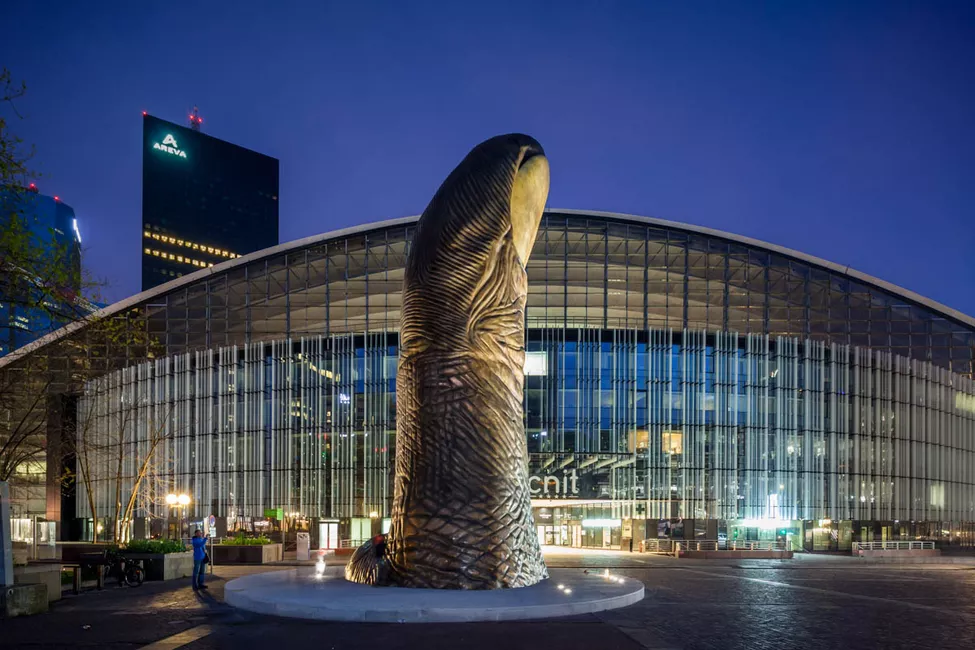 45. © Photo to 11 h 45 showing a large metal thumb art installation outside a modern corporate office space in the middle of paris taken in the night 