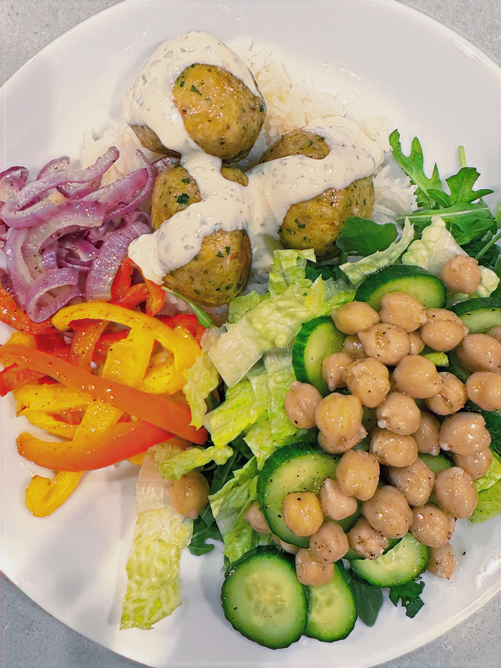 chicken shawarma meatballs with yogurt tahini sauce and roasted peppers and onions