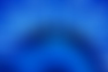 Person lies under an arc of blue LED lights, wearing protective goggles. The setting is futuristic and serene, with bright blue hues.