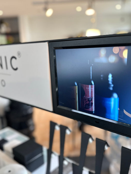 Digitalanzeige mit Produktvisualisierung über Kosmetikregal im Verkaufsraum