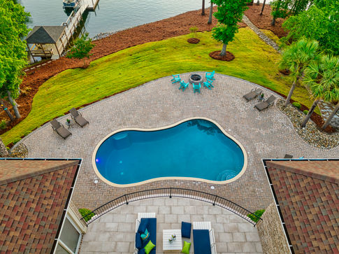 Aerial drone photograph at sunrise looking at a 60 degree angle at a luxury home with a pool on Lake Murray in South Carolina.
