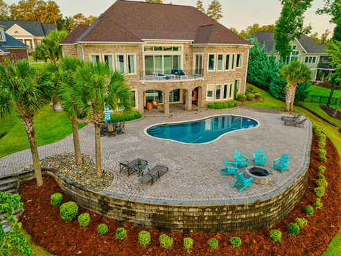 Aerial drone photograph at sunrise of the back of a luxury home with a pool on Lake Murray in South Carolina.