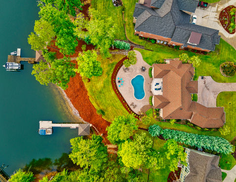 Aerial drone photograph at sunrise looking straight down at a luxury home with a pool on Lake Murray in South Carolina.
