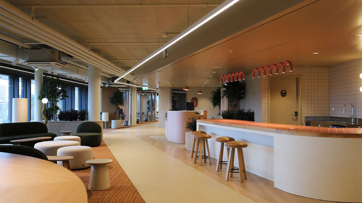 Espace de détente avec des sièges confortables, des plantes vertes et un design apaisant, offrant un endroit parfait pour se relaxer après une journée bien remplie.