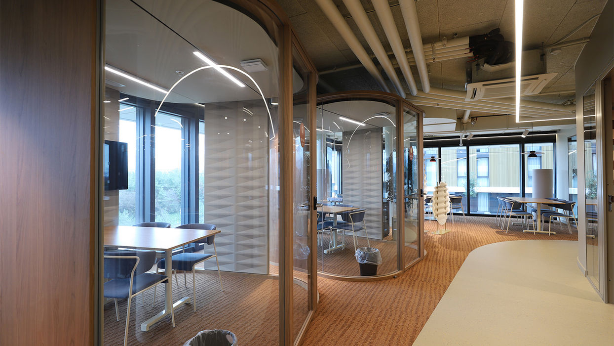 Espace de coworking lumineux avec des bureaux partagés, des chaises ergonomiques et un design collaboratif, favorisant la productivité des résidents.